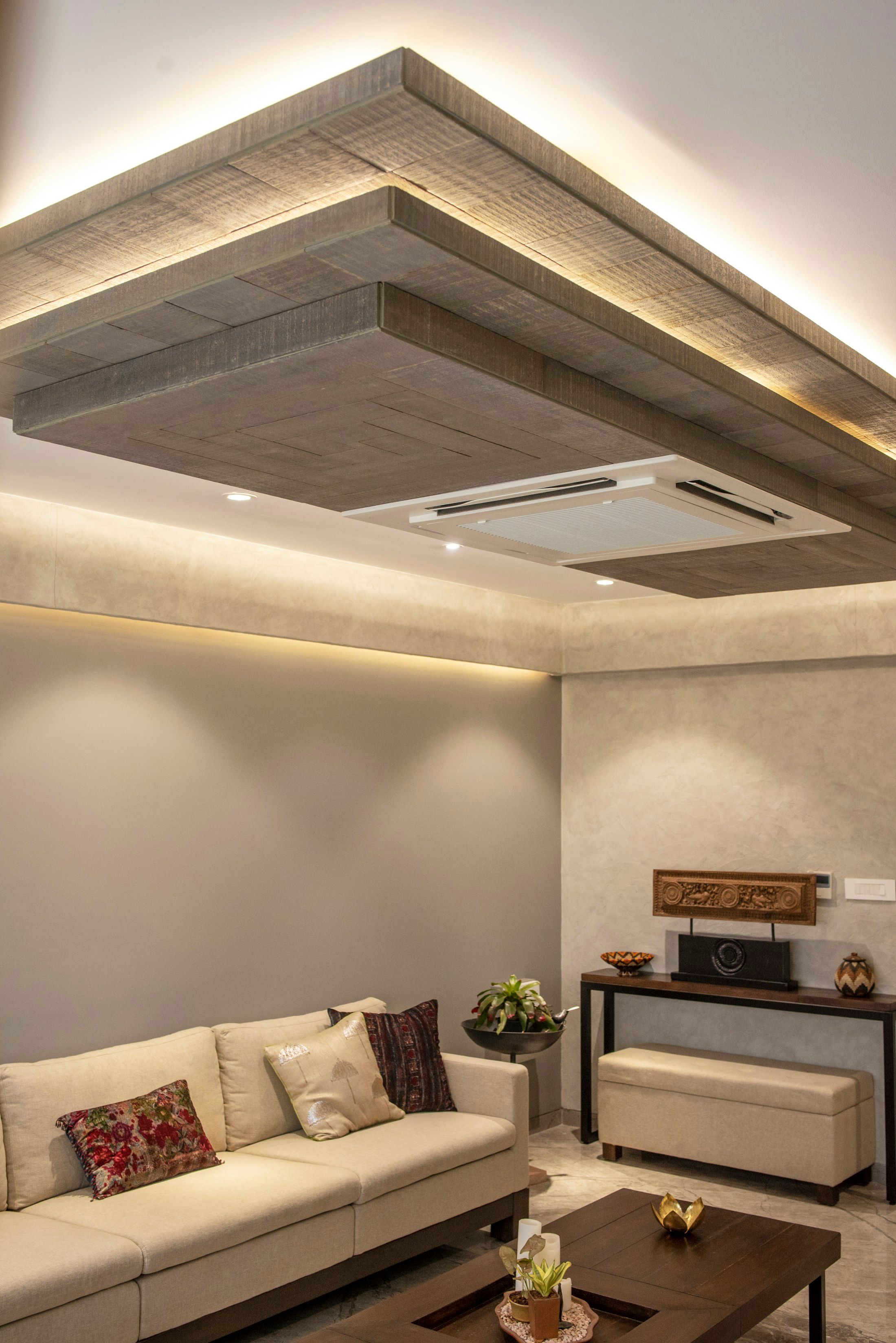 Sala com tecto falso flutuante em camadas e luz indirecta quente