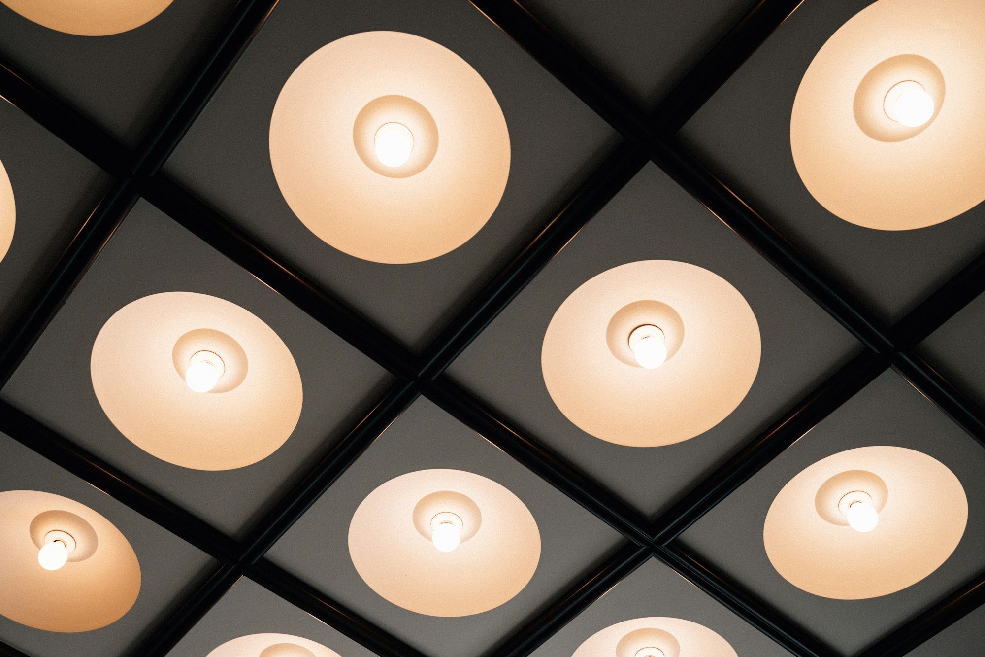 Tecto escuro em quadrícula com focos de luz embutidos